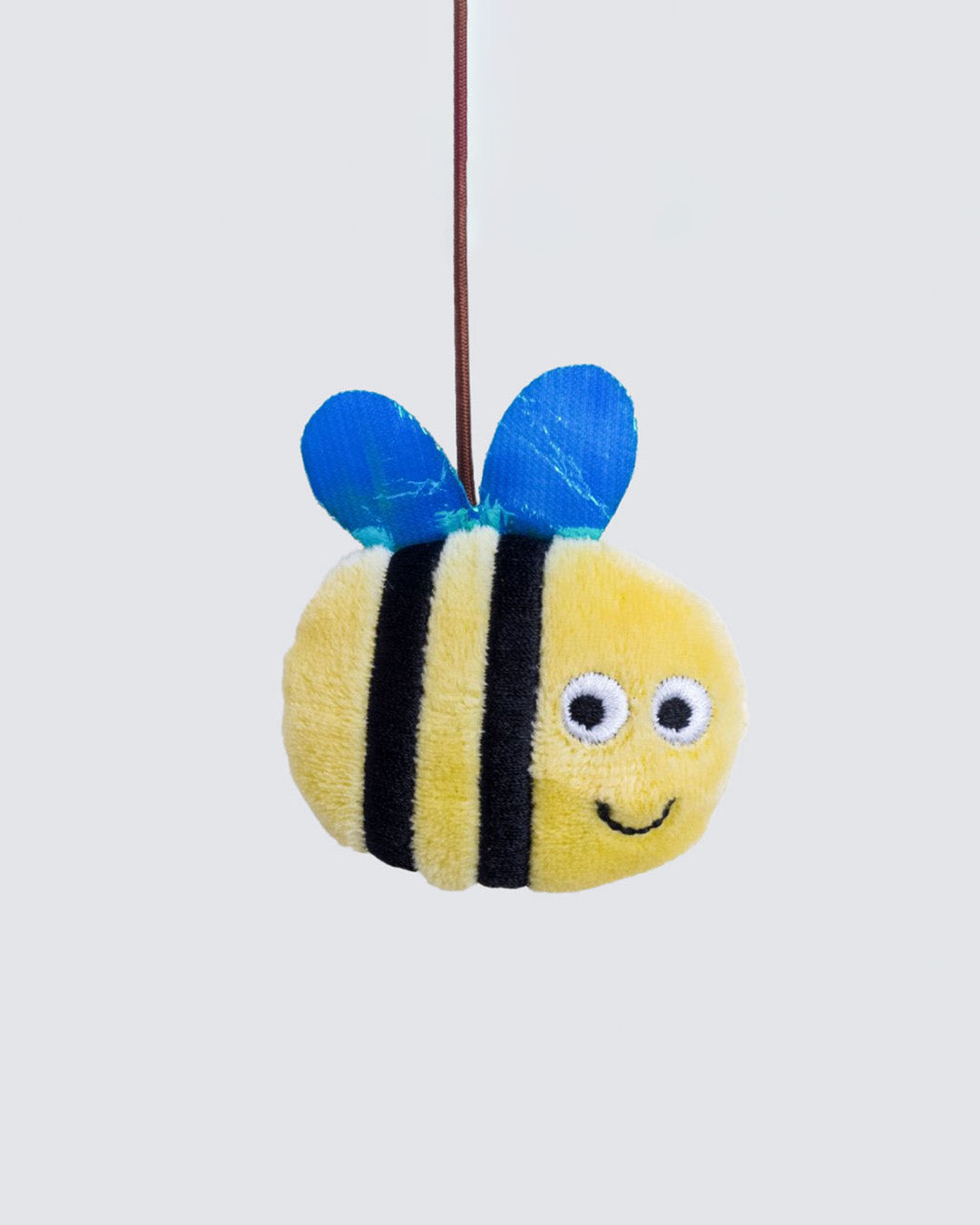 Close-up of catnip-filled yellow plush bee hanging from wand string