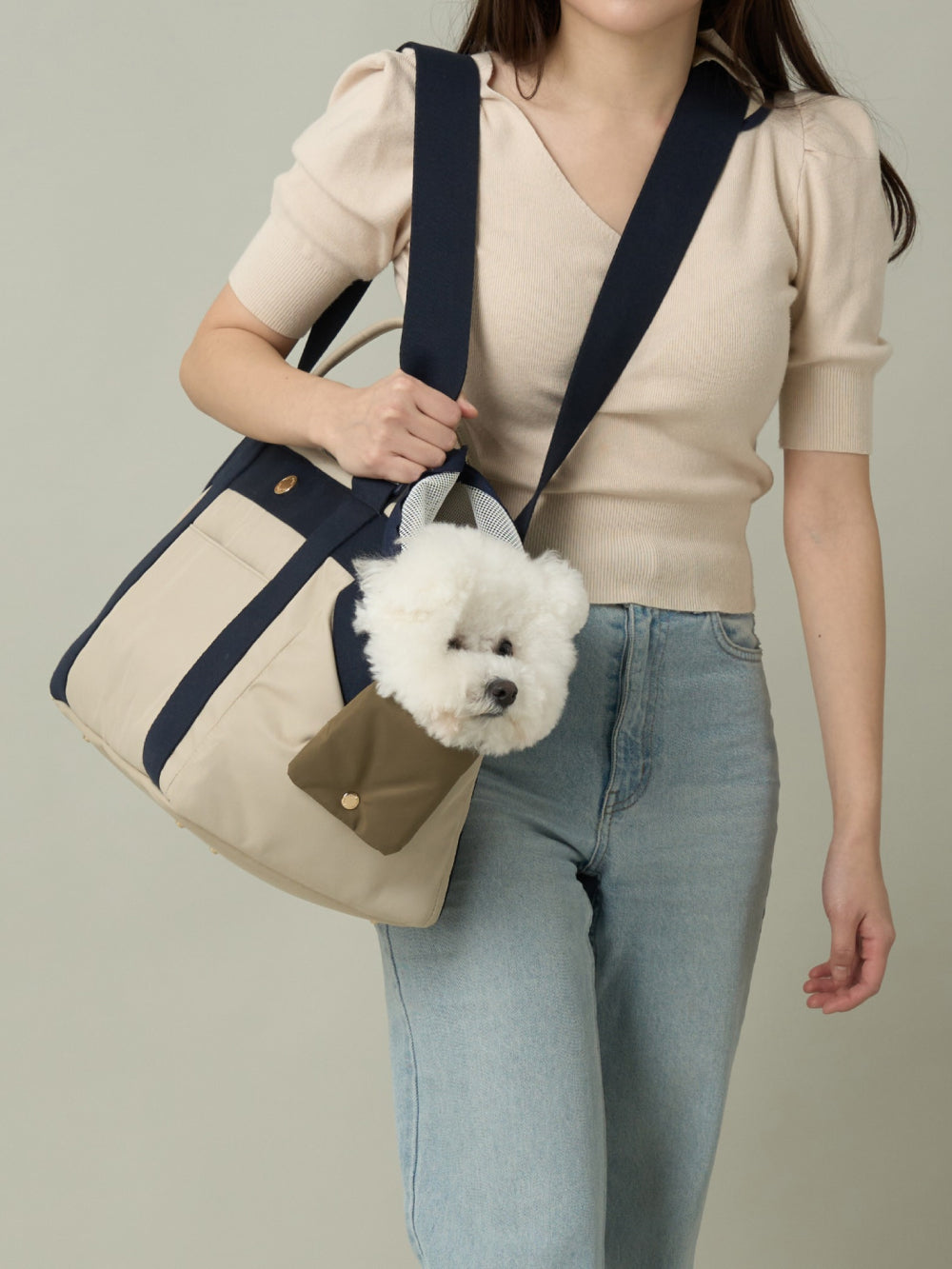 A small dog comfortably being carried inside the Bagel Bag.