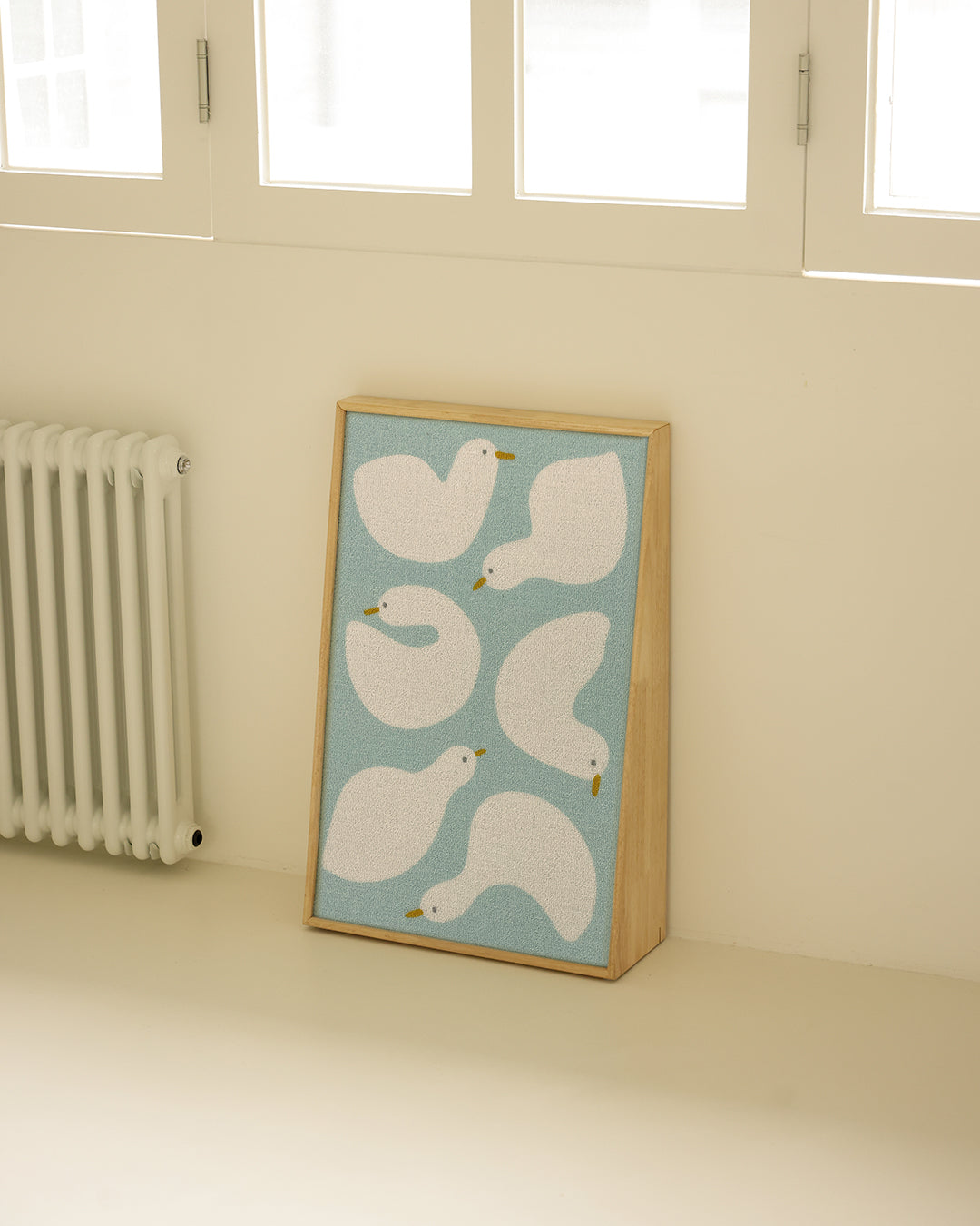 Wood frame Duck Buddies scratcher leaning against the wall of a bright room