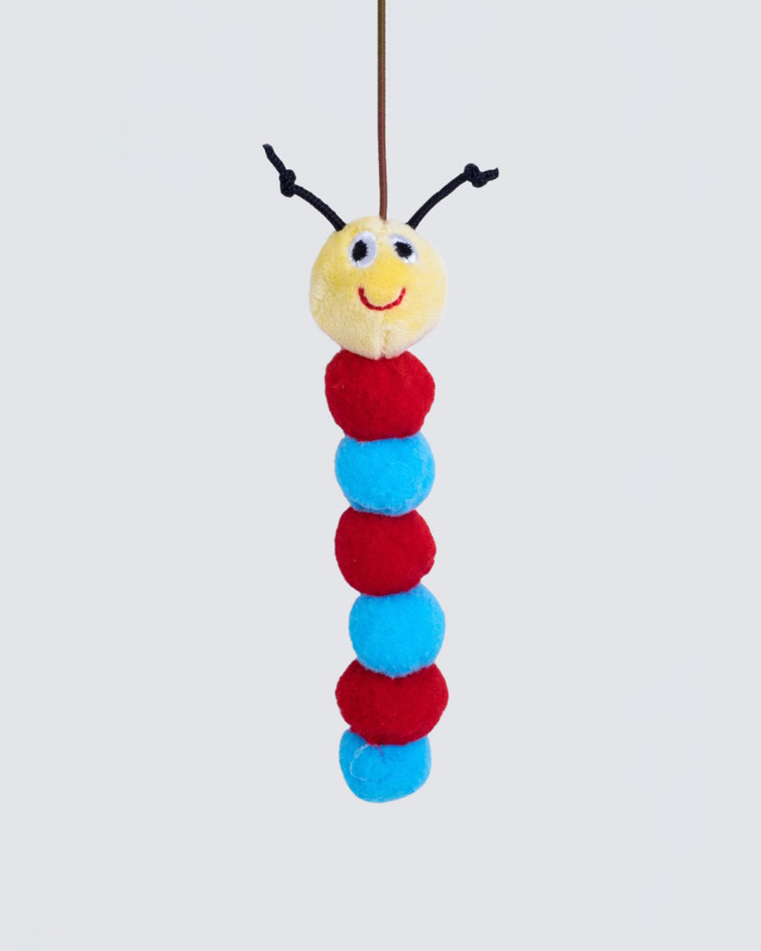 Close-up of catnip-filled plush caterpillar hanging from wand string