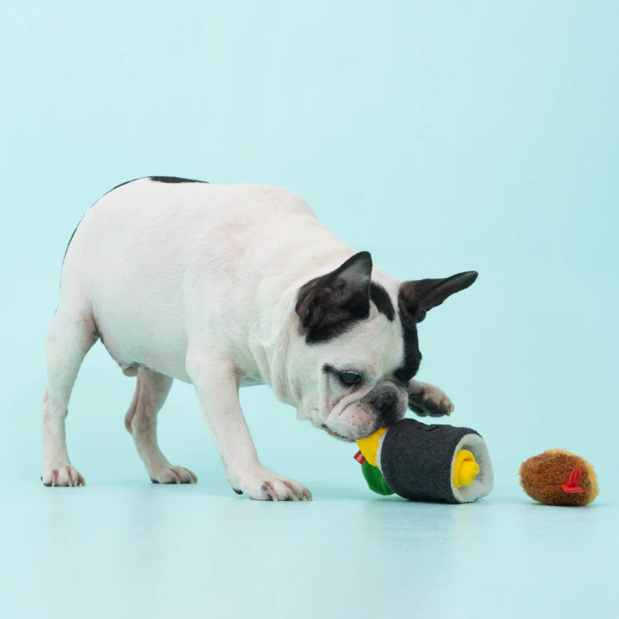 A dog tugging at the seaweed rice wrap of the Giant Gimbap Nosework Toy, enjoying its soft texture.